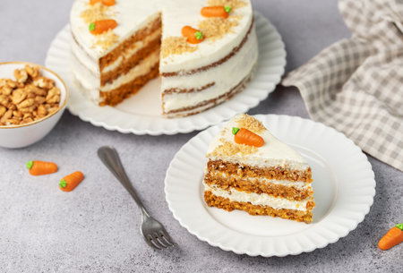 Homemade carrot cake made with walnuts, iced with cream cheese. Sweet dessert.  Plate with delicious...
