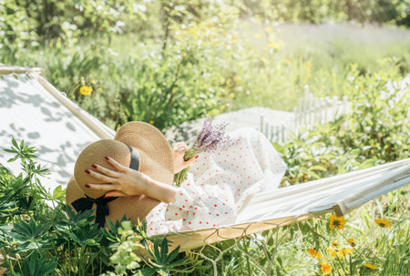 Young woman relaxing in a hammock outdoors in back yardの写真素材