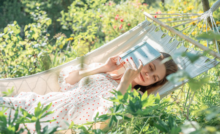 Young woman relaxing in a hammock outdoors in back yardの写真素材