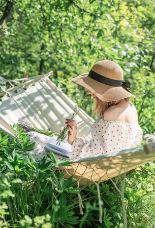 Young woman relaxing in a hammock outdoors in back yardの写真素材