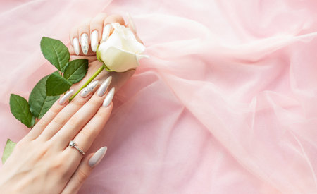 Female Hands with beautiful pearl manicure and white rosesの写真素材