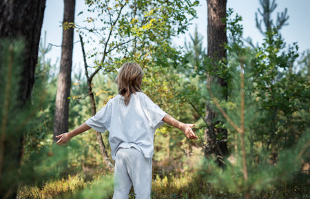 A teenage girl who breathes fresh air and relieves stress in the forest. Dreamy peaceful relaxed girl breathing the fresh air of nature.の写真素材