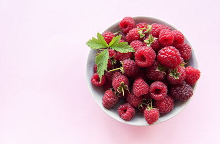 Fresh organic ripe raspberries with leaves