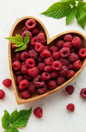 Fresh organic ripe raspberry with leaves on a concrete  backgroundの写真素材