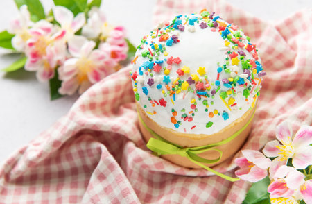 Traditional easter cake with colorful sprinkles, tied with a green ribbon and surrounded by spring...