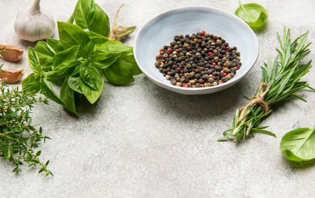 Aromatic herbs, spices, and colorful chili peppers arranged on a textured surface, ready to enhance culinary creationsの写真素材