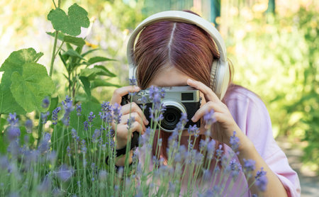 Teen enthusiast photographing flowers in a garden settingの写真素材