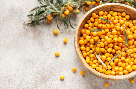 Sea buckthorn berries filling wooden bowl, offering healthy, organic, nutrient rich superfood...