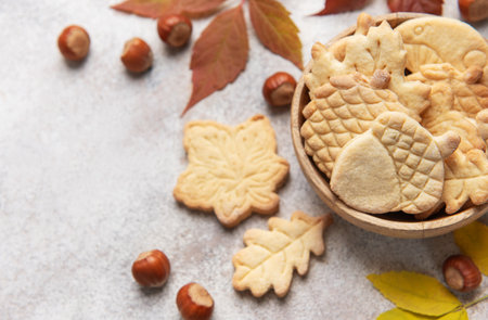 Homemade autumn shaped cookies with hazelnuts and fall leaves on a gray backgroundの写真素材