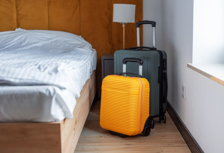 Two travel suitcases waiting in a clean, contemporary hotel room for a journeyの写真素材