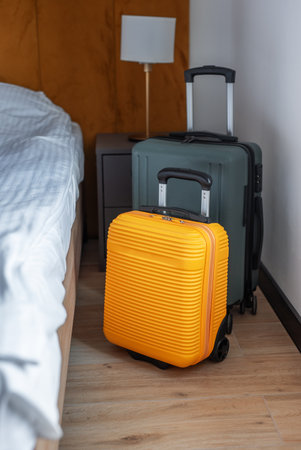 Two travel suitcases waiting in a clean, contemporary hotel room for a journeyの写真素材