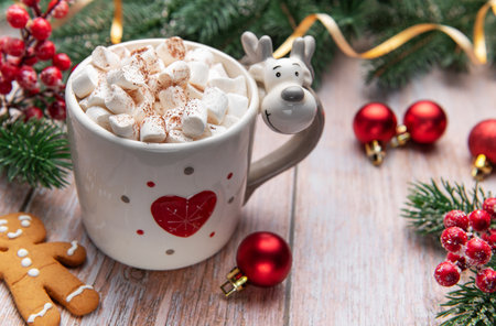 Cozy hot chocolate in a festive reindeer mug with marshmallows and gingerbread manの写真素材