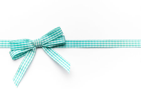 Gingham ribbon bow providing a celebratory border on a clean white backgroundの写真素材