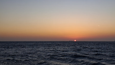 Sunset over the sea. The sun sets over the horizon.の写真素材