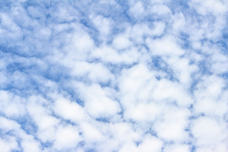 Fluffy clouds drift across a clear blue sky, creating a calming and serene atmosphere, perfect for...