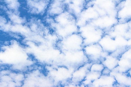 Vast blue sky adorned with soft white clouds, providing a tranquil ambiance ideal for backgrounds,...