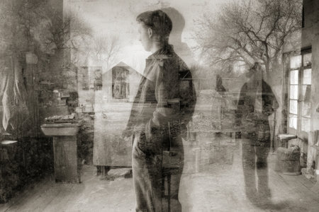 Male figure stands in a vintage workshop, looking out the window, with a soft double exposure effect adding depth and a sense of contemplation to the sceneの素材