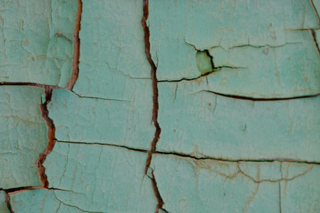 Detailed close-up of aged turquoise paint on wooden surface, revealing cracks and textures,...