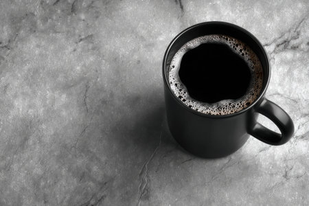 Matte black mug filled with black coffee rests on a sleek marble surface, highlighting the contrast of textures and creating a modern, inviting atmosphere for coffee enjoymentの素材