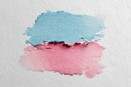 Soft pastel blue and pink watercolor brush strokes on textured paper create a visually appealing illustration, showcasing a delicate blend of colors and artistic expressionの素材