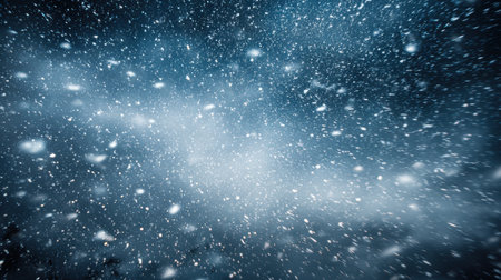 Photography captures heavy snowfall against a deep navy sky, showcasing crisp white flakes and a tranquil winter ambiance, perfect for seasonal themesの素材