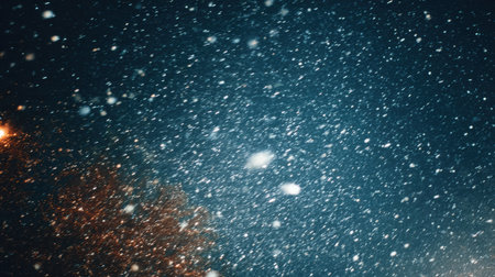 Photography captures dense snowfall against a rich navy night sky, showcasing high contrast and crisp white flakes, evoking a tranquil winter ambiance with copy spaceの素材