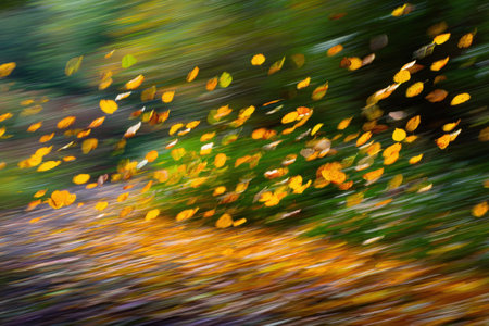 Swirling autumn leaves in vibrant colors create a dynamic background, showing the beauty of seasonal change with a blurred effect that evokes movement and energyの素材