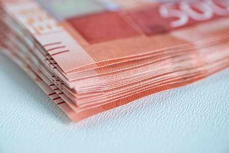 Close-up image of stacked banknotes displaying intricate details and textures, with visible...