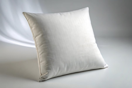 Square white pillow isolated on white background with soft lightingの素材