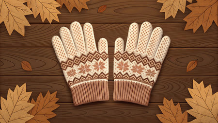 Knitted gloves with autumn leaves on a wooden background, top viewの素材