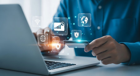 A person is holding a credit card and interacting with a laptop, surrounded by holographic icons representing business and social media.の素材