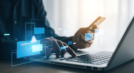 Close up of a man using laptop and smartphone for online banking and payment transaction. Concept of finance and e-commerce. Modern technology and business.の素材