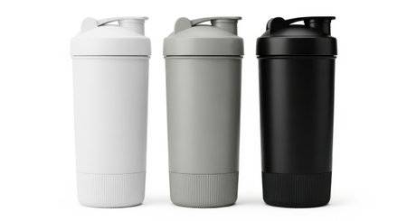 Three protein shakers, in white, gray, and black, stand ready for your fitness needs. Isolated on white, they offer a clean and modern aesthetic.の素材