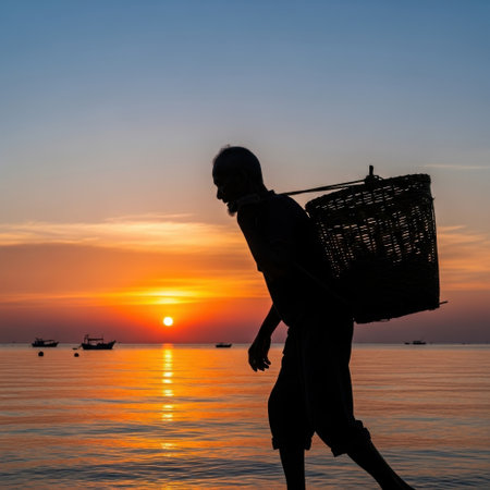 A fisherman is silhouetted against the sunset, carrying his catch on the beach. The scene captures the essence of coastal life, hard work, and the beauty of nature.の素材