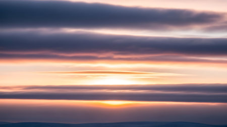 Dramatic sunset sky with streaky clouds and warm golden and purple huesの素材