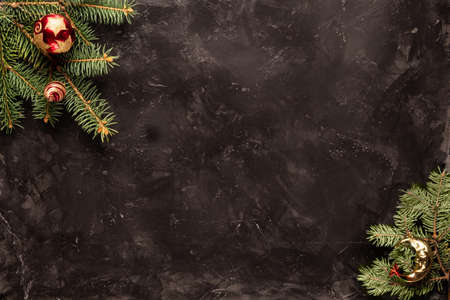 Fir branches with toys balls on a black background. The background for the label free spaceの写真素材