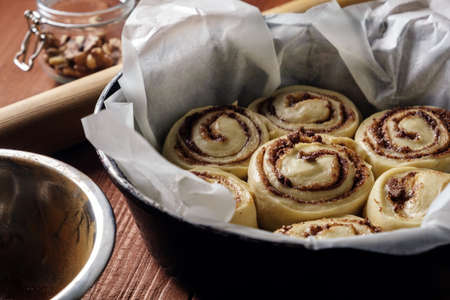 Cinnamon rolls. Freshly baked cinnamon buns with spices and cocoa filling on parchment paper. Top view. Sweet Homemade Pastry christmas baking. Close-up.の写真素材