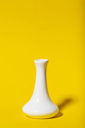white vase on a yellow backgroundの写真素材