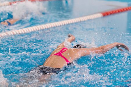 Swimming pool athlete training indoors. Girl doing butterflyの写真素材