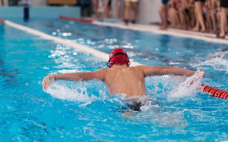 Swimming pool athlete training indoors. Guy doing butterflyの写真素材