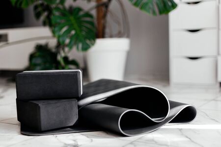 yoga at home. gray yoga mat and black yoga blocks in a white light roomの写真素材