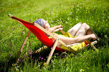 Young woman sitting in a deck chair.の写真素材