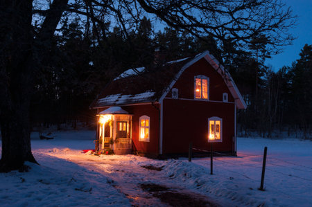 Red painted Swedish wooden house in a wintry landscapeのeditorial素材