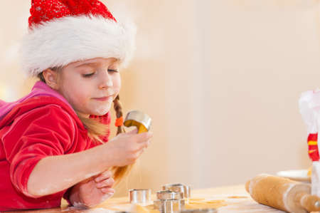 Cute little girl preparing cookies for christmas Focus on the girls faceの写真素材