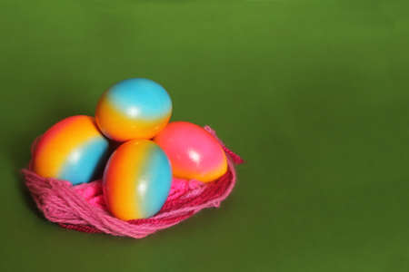colorful eggs in nest on greenの写真素材