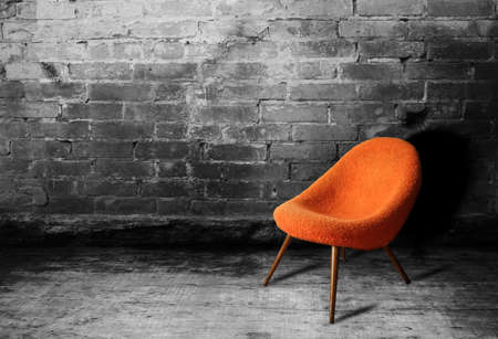 Old orange chair on a wall