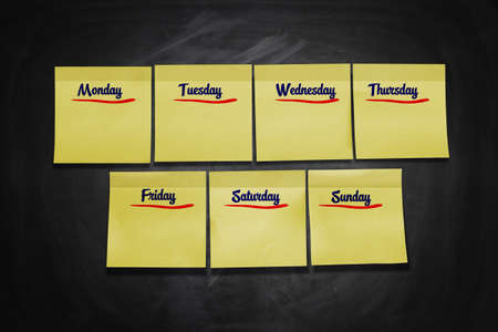 Days of Week Stick Notes on black boardの写真素材