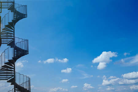 Industrial spiral stairway on sky background