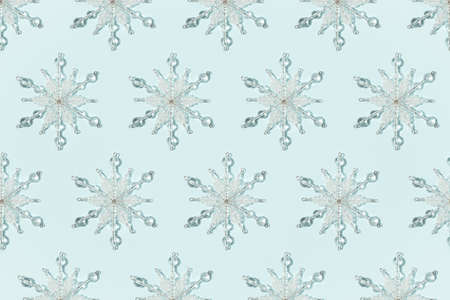 Abstract pattern of decorative snowflakes on a fastel blue backgroundの写真素材