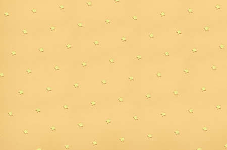 Minimalistic golden star pattern on a warm toned background. Luxury but also simple and stylish. Good for wrapping, backdrops, wallpaper etcの写真素材